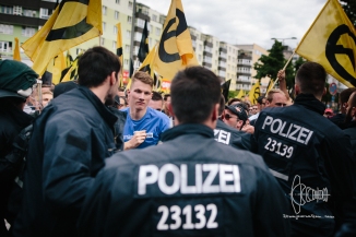 Up-front: Members of the Bavarian Identitarian Movement, such as Paul Z. in the left of the picture - raising his fist towards police.